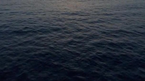 缓慢倾斜揭示了日落时飞越海面的无人驾驶飞机射击 — 图库视频影像