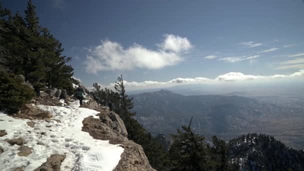 Female Hiker Walks Edge Snowy Cliffside Mountains — ストック動画