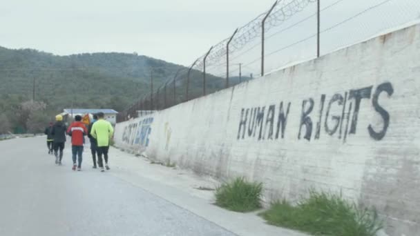 Group Refugees Running Moria Camp Graffiti Human Rights Graveyard Welcome — стоковое видео