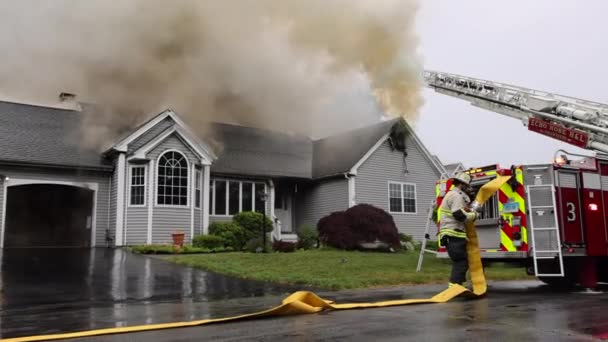 Firefighter Prepares Fire Hose Ouside Intense House Fire — стоковое видео