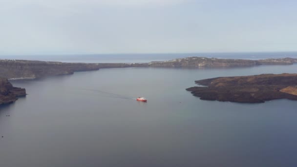 日の出の間にギリシャのサントリーニ島の港で穏やかな海を渡る船のパノラマビュー — ストック動画