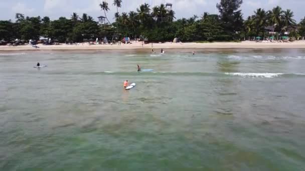 Drohne Fliegt Über Menschen Die Auf Surfbrettern Richtung Sandstrand Mirissa — Stockvideo