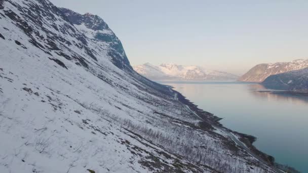 Flyg Längs Brant Snötäckt Bergssluttning Naturskön Väg Intill Fjord — Stockvideo