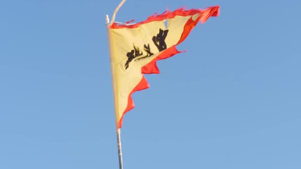 スローモーション低天使ショットのアクアルナ赤と黄色の三角形の旗が背景に青空と手を振って — ストック動画