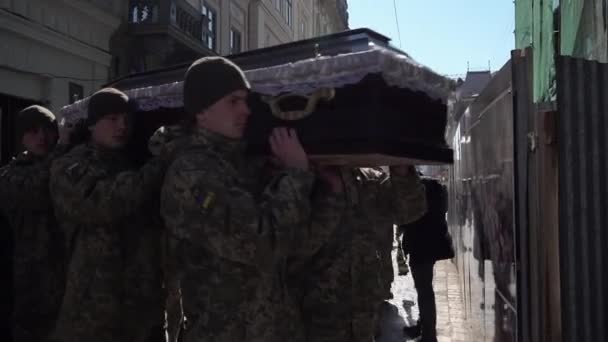 ウクライナの兵士はロシアの侵攻中に兵士の葬儀のために教会に肩に棺を運ぶ — ストック動画