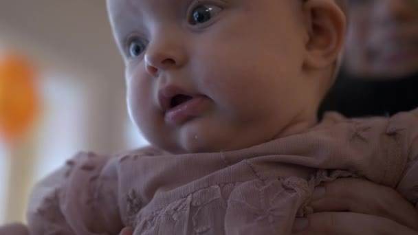 Parent Holding Dressed Happy Baby Girl Alert Eyes Close Face — Stock Video