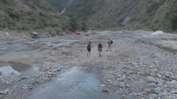 Three Men Hiking Trekking Rocky River Bed Crossing Creek Remote — Stockvideo