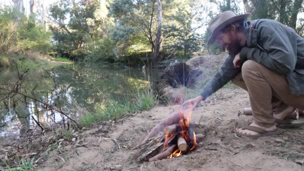 Bushman Karmiący Ogień Piaszczystym Brzegu Strumienia Krzakach Australii — Wideo stockowe