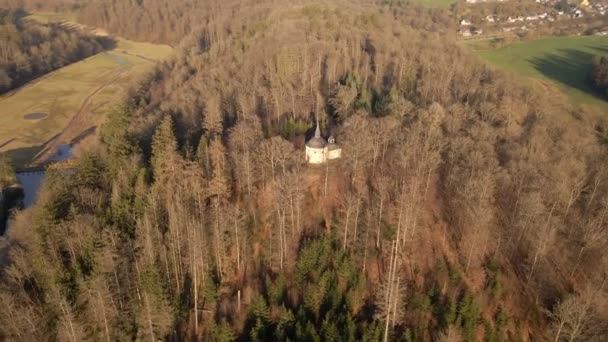 山顶上的小教堂 上面覆盖着干燥的棕色森林树冠 空中轨道中弹 — 图库视频影像