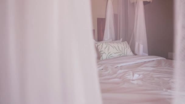 A bed in a hotel room filmed through a curtain