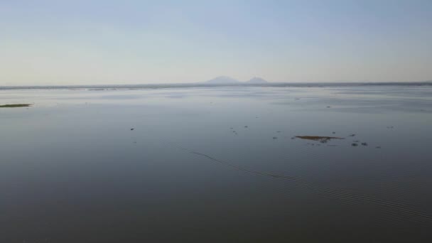 Filmato Aereo Sul Lago Verso Due Colline All Orizzonte Bueng — Video Stock