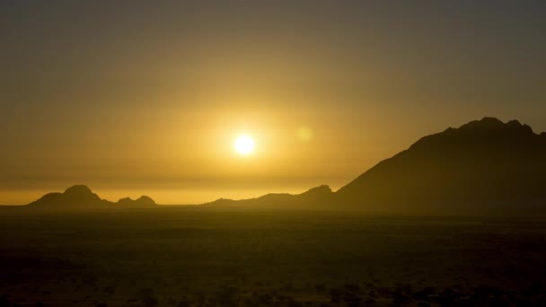 ナミビアの静かな山の後ろに暖かい色の空を背景に美しい夏の太陽の設定 ワイドショット — ストック動画