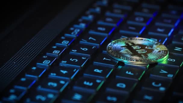 BitcoinゴールデンコインがバックライトRgbキーボードに横たわっている 暗号技術の概念 — ストック動画