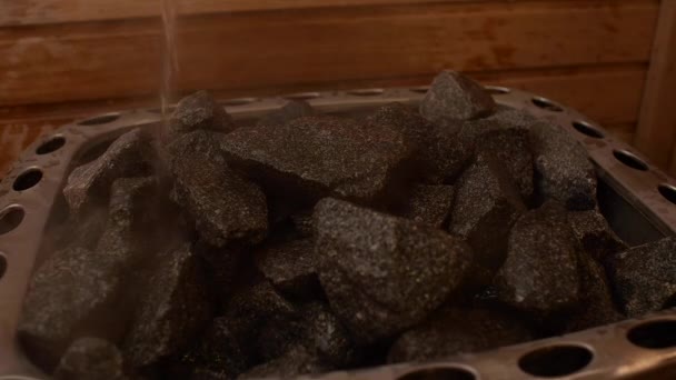 看到一个传统的桑拿与水溅在热的石头上冷却它在空桑拿内 芬兰木制桑拿浴室的内部 有水疗室 可供深度放松 — 图库视频影像