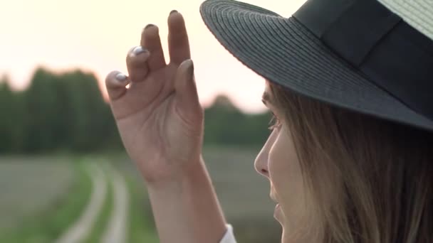 このスローモーションショットでは 若い女性が指で帽子の端に触れている様子を見ることができます 夏休みなどのトピックのための完璧なビデオ — ストック動画