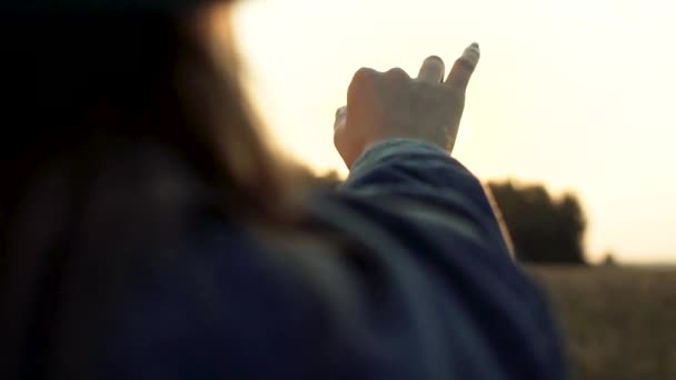 电影慢镜头近距离拍摄 你可以看到浪漫的嬉皮士女人在黄昏时与太阳光玩耍 她正试着用手指把太阳握在掌心 — 图库视频影像