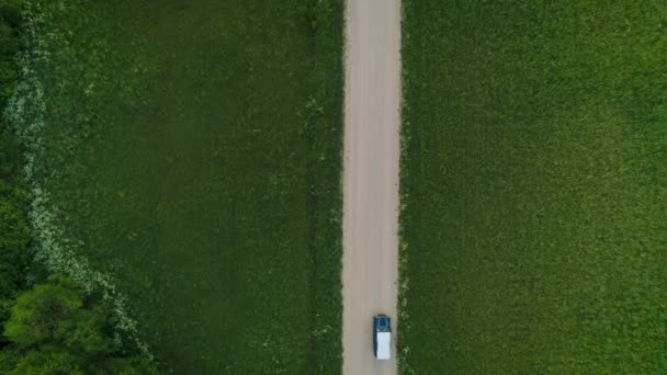 在绿地环绕的乡村 你可以看到蓝色吉普车在砾石路上行驶 — 图库视频影像