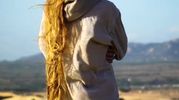 长长的金发 波浪般的强风 年轻女子从背后站在自然景观的观点让人惊叹不已 — 图库视频影像