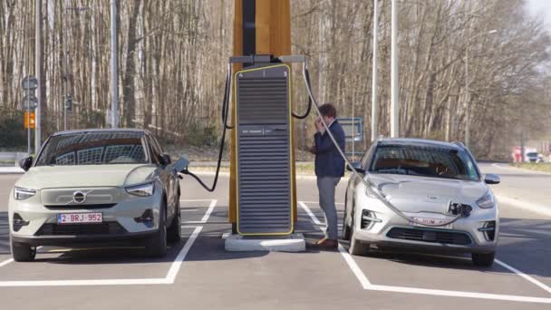 Lone Young Man Impatiently Pacing While His Electric Car Recharges — ストック動画