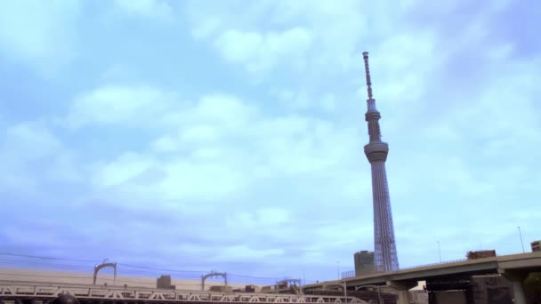 东京斯基特雷 Tokyo Skytree Asakusa Tokyo Japan 大约在2020年4月左右 在桥上行驶的卡车和汽车穿过轨道 火车运行缓慢 在平静的云彩和天空中显示出象征性的地标 — 图库视频影像