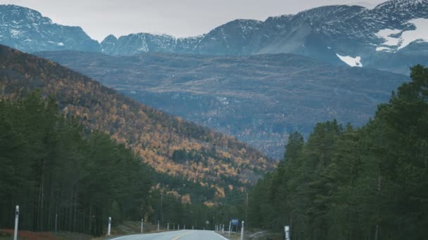 这条双车道的乡间公路穿过秋天的山谷 山顶上的新雪 慢动作 向前开 — 图库视频影像