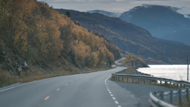 Wąska Dwupasmowa Droga Węży Wzdłuż Fiordu Ośnieżone Góry Horyzoncie Zwolnij — Wideo stockowe