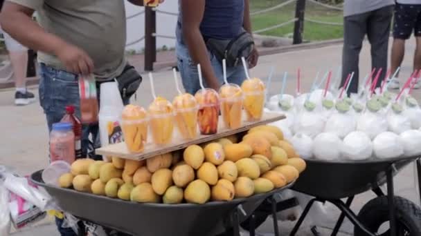 卖主在Playa Del Carmen第五大道出售芒果和椰子的慢镜头 — 图库视频影像