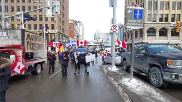 人々は旗を持って歩き カナダのオンタリオ州オタワでの自由の船団の抗議で封鎖された通りで抗議の兆候 — ストック動画