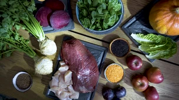 キッチンテーブルの上で新鮮な生肉や野菜料理の食材 — ストック動画