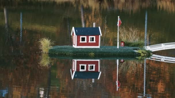 在挪威索里萨市的公园里 一个田园诗般的场景 湖心挂着挪威国旗的小型住宅反映在镜像静水中 背景中的秋叶 — 图库视频影像