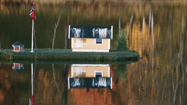 在挪威索里萨市的公园里 一个田园诗般的场景 湖心区有悬挂挪威国旗的小型住宅 秋天的树叶倒映在镜子般的静水里 — 图库视频影像