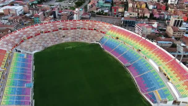 空のピッチとカラフルな座席ペルーのクスコにあるサッカースタジアム Estadio Garcilaso Football Stadiumで 空中後退 — ストック動画