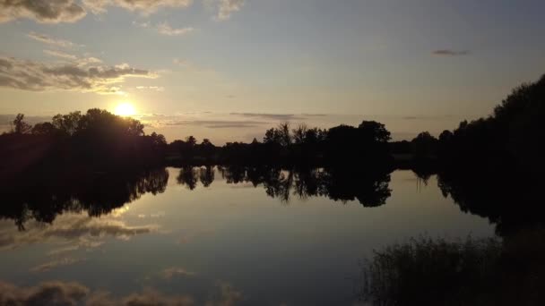 ブランデンブルクの小さな村の湖で夏の日没時に100万ドルの空中ドローンフライトスライダーが横に飛ぶ 太陽の雲と空の水の中にミラーリング フィリップ マルニッツの映画的自然観 — ストック動画