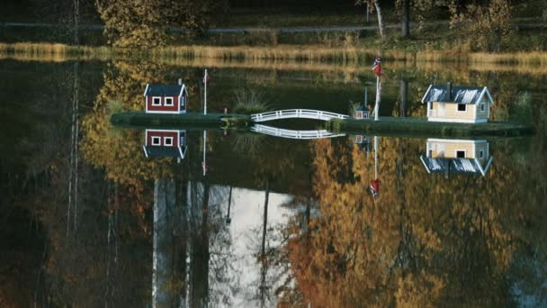 ノルウェーのフィンスネスの町の牧歌的なシーン 湖の真ん中におもちゃの家は鏡のようなまだ水に反映されます 背景には鮮やかな紅葉 — ストック動画