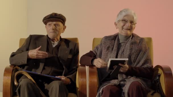 Elder Couple Looking Photograph Laughing — Vídeos de Stock