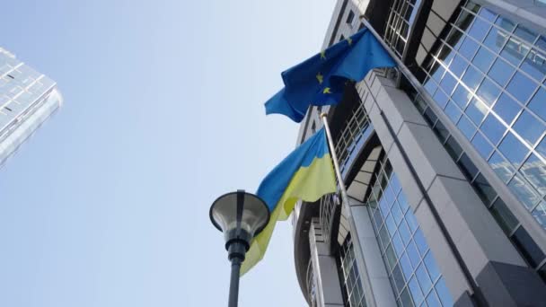 在比利时布鲁塞尔欧洲议会前挥动乌克兰和欧洲国旗 — 图库视频影像