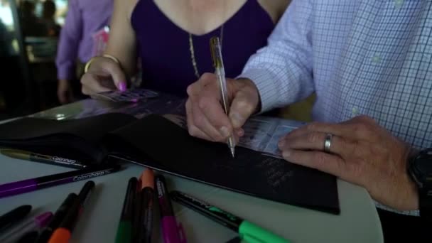 Ein Mann Und Eine Frau Unterschreiben Eine Karte — Stockvideo