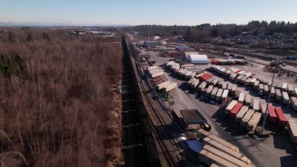 カナダのバンクーバー シッピング ターミナル横の鉄道で運行されている貨物列車 空中前方 — ストック動画