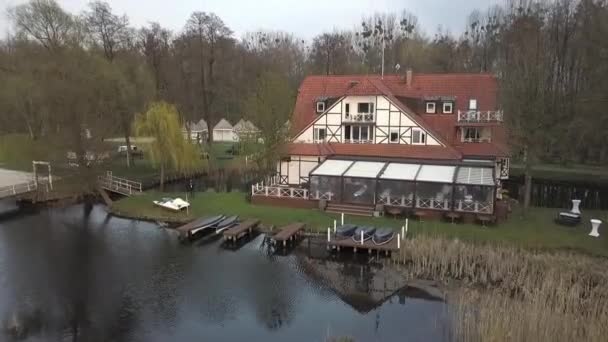 在德国勃兰登堡一个完美的婚礼地点 在春日落日落山的湖面上 考默尔用空中无人驾驶飞机飞往白色的半木房子 在码头上挂着小船 菲利普 马尔尼茨的电影自然观 — 图库视频影像