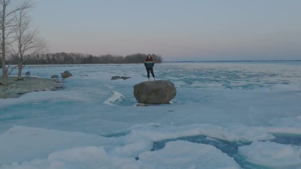 Young Women Wearing Pride Colors Jacket Rock Middle Frozen Lake — Vídeo de Stock