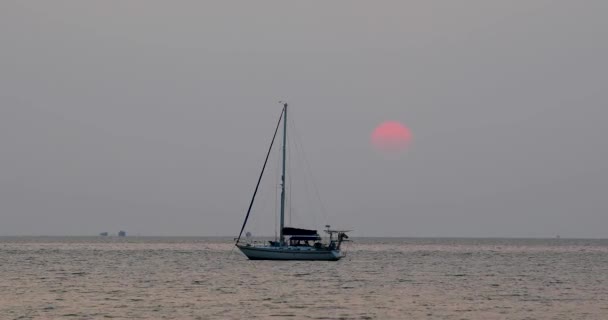 大きな太陽が沈む美しい夕日タイのパタヤの近くにあるバンサライのホライズンでヨットの後ろに行きます 4Kで静止ズームショット — ストック動画