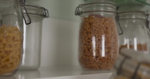 Hands Putting Airtight Jar Raw Noodles Cupboard Gimbal Close — стокове відео