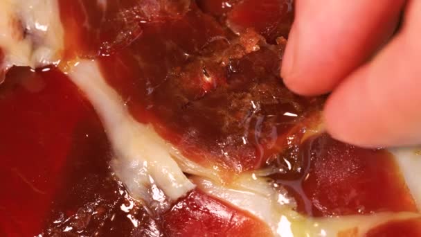 Man Hand Picking Slice Oily Top Quality Serrano Ham Bunch — стоковое видео