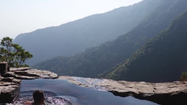 Man Simma Naturlig Pool Vid Berget Klippa Från Topp Vinklar — Stockvideo