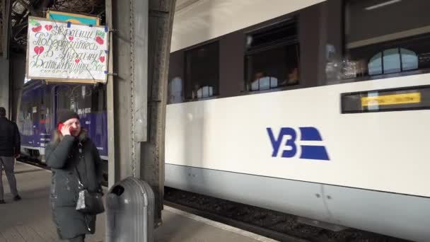 一列载着逃避俄军入侵的难民的火车驶离火车站 经过一个手写的标牌 上面写着 乌克兰人回到乌克兰 你的父母在等你 — 图库视频影像