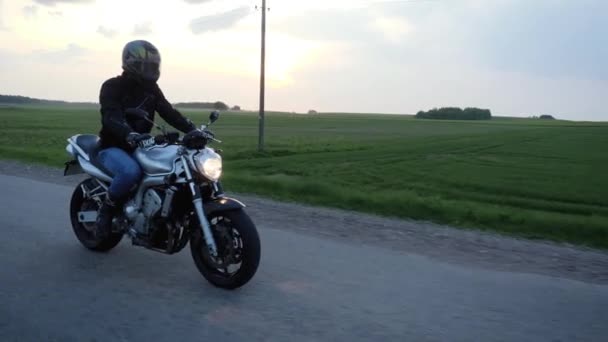 Motocyklista Odzieżą Motocyklisty Jeżdżący Swoim Srebrnym Rowerze Ulicznym Gdzieś Wsi — Wideo stockowe