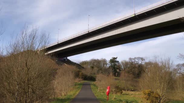 Derry Londonderry City Northern Ireland 汽车和卡车穿过巨大的Foyle桥的西段 穿过一条蜿蜒曲折的小径 穿过灌木丛中的公园 驶向Culmore路 — 图库视频影像
