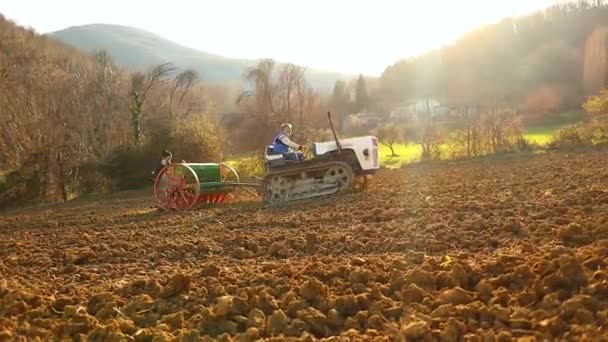 Mezőgazdasági Termelők Traktor Vetőgép Dolgozik Földet Naplementekor Földszinti Lövés — Stock videók