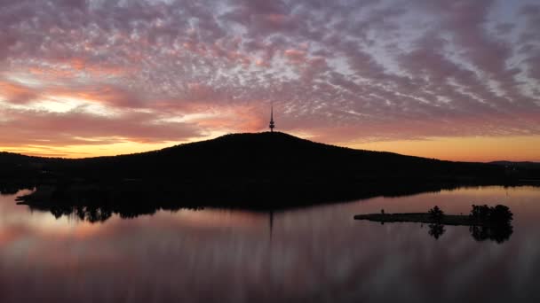 堪培拉夕阳西下的轮廓在伯里格里芬湖上空 还有特尔斯特拉塔和黑山 多彩的天空地平线和反光 — 图库视频影像