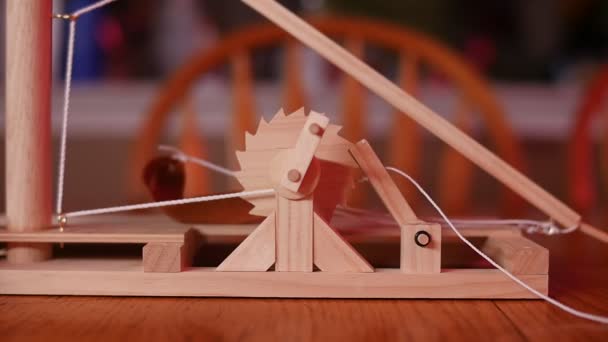 Slow Motion Close Toy Wooden Trebuchet Firing Wooden Table Chair — Stockvideo